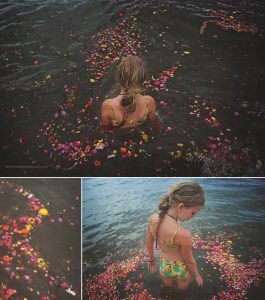 a girl sits in water surrounded by flowers on a beach in Chennai, India, by Kirsty larmour