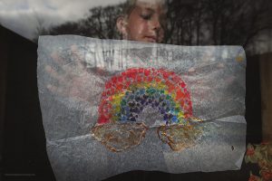 Kirsty Larmour - a girl holds up a rainbow painted out of love hearts during the Covid-19 lockdown