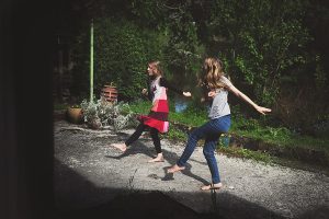 2 girls dancing together in their back yard in Yorkshire, England